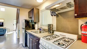 Una cocina compacta con estufa a gas, refrigerador y pileta.