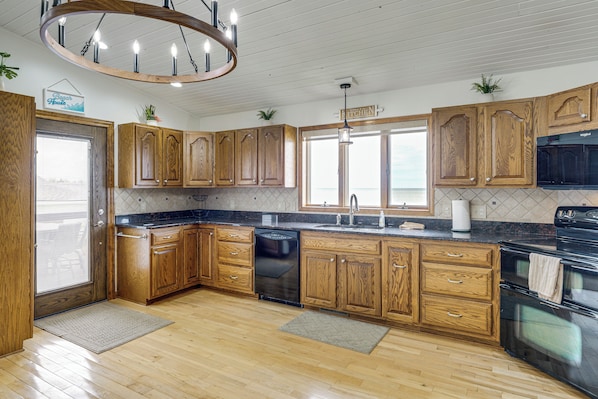A kitchen with wooden cabinets, a black dishwasher, and a double oven.