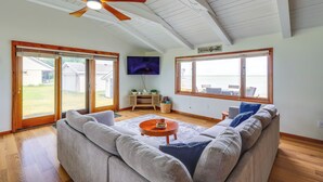 A spacious living room with a large sofa, a coffee table, and a ceiling fan. - Waterfront Lake Huron Getaway w/ Private Beach (Port Hope)