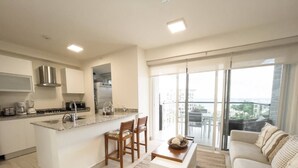 Un appartement moderne comprenant une cuisine, un coin repas et un salon.