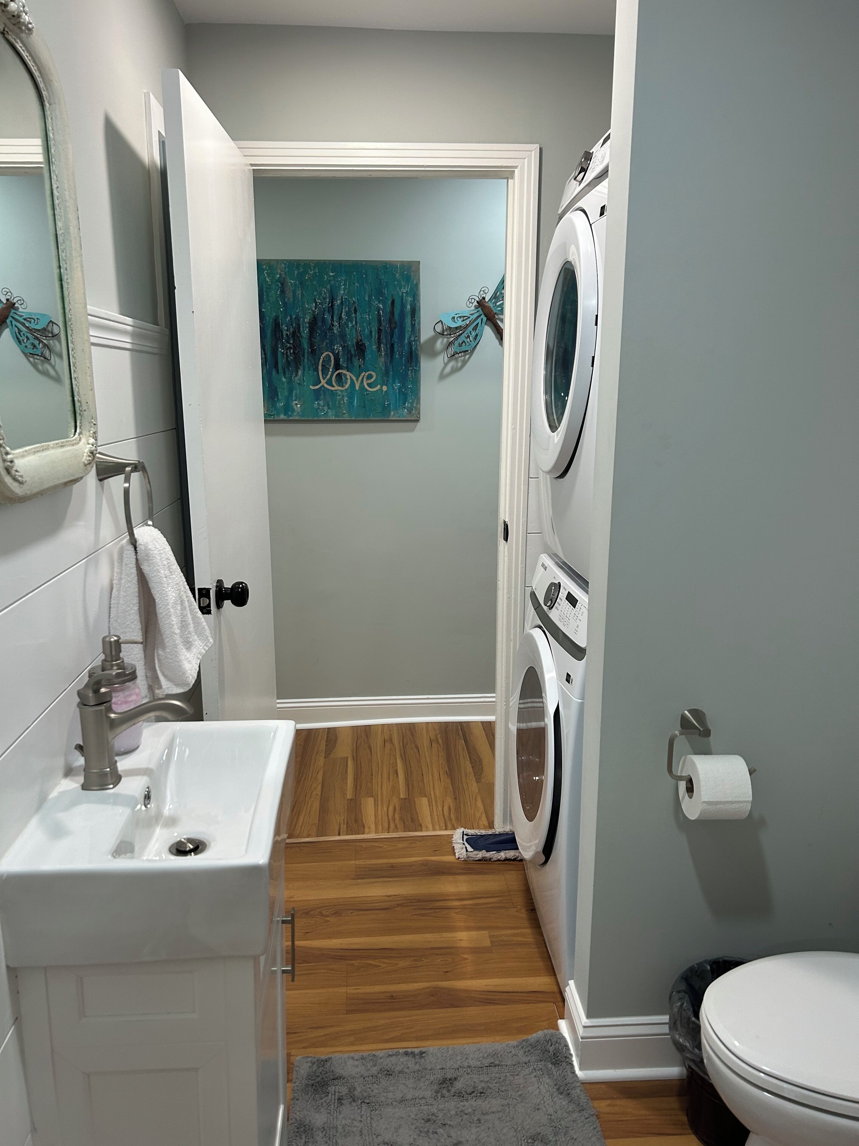 Une petite salle de bain comprenant un lavabo, un miroir et un lave-linge.