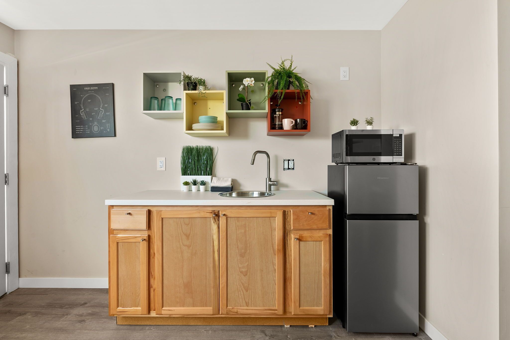 Une cuisine moderne avec des meubles en bois, un évier en acier inoxydable et un four à micro-ondes encastré.
