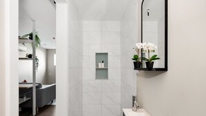 A modern bathroom with a shower, sink, and mirror. There are plants and a towel rack. - Comfortable New Room in one of San Diego's best Neighborhoods (San Diego)