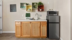 A modern kitchen with wooden cabinets, a stainless steel sink, and a built-in microwave.