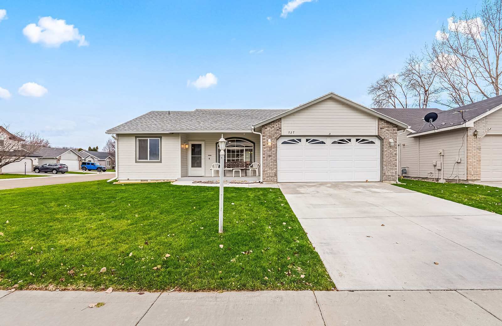A single-story house with a garage, a front porch, and a well-maintained lawn.