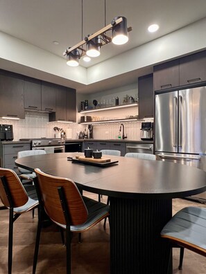 A modern kitchen with a central island, stainless steel appliances, and a contemporary design. - NEW Condo w/ VIEWS — Sleeps 9 w/ Pool, Hot Tub! (Canmore)