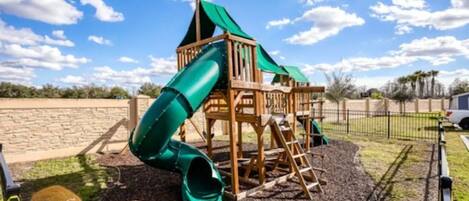 A playground with a slide and climbing structures.
