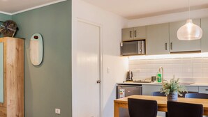 Eine moderne Küche mit Essbereich, Holzschränken, einer Mikrowelle und einem Deckenventilator.