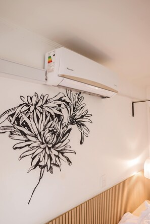 A wall with a black floral decal, a ceiling-mounted air conditioner, and a wooden slat wall design. - Trendy Bellavista Haven for 2 – Perfect Location! (Providencia)