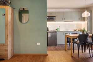 A modern kitchen with a dining area, wooden cabinets, a microwave, and a refrigerator. - Trendy Bellavista Haven for 2 – Perfect Location! (Providencia)