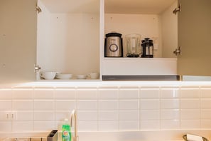 A kitchen with white tiles, a coffee maker, a blender, and a kettle on the counter. - Trendy Bellavista Haven for 2 – Perfect Location! (Providencia)