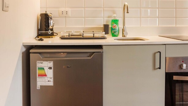 Een kleine keuken met een magnetron, broodrooster, spoelbak en vaatwasser.
