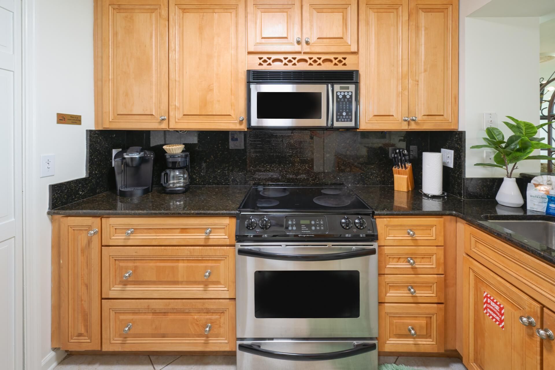 A kitchen with wooden cabinets, a stainless steel microwave, a gas stove, and a built-in oven.