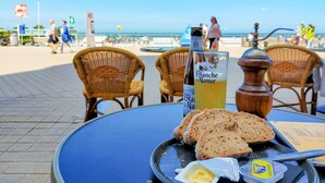 Ein Tisch mit einer Flasche Blanche de Narmer, Brotscheiben, Butter und einer Gewürzmühle.