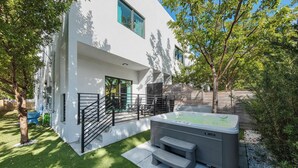 A modern house with a hot tub, a staircase, and a small deck. - Group getaway w/ soccer suites & hot tubs (Miami)