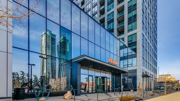 A modern building with a glass facade, a prominent entrance, and a sign reading 'BIVID'. - Elegant 1-Bedroom at BLVD Beltline (Calgary)