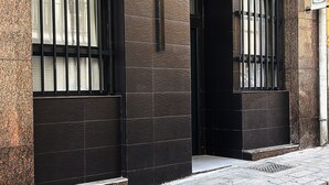 A building facade with two large windows, each with black metal bars, and a sign reading "ALMA ONE". - ALMA one (Alicante)