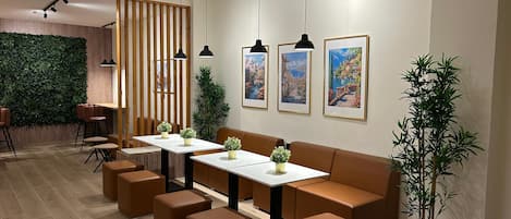 A modern interior with a wooden partition, a sofa, tables, and potted plants.