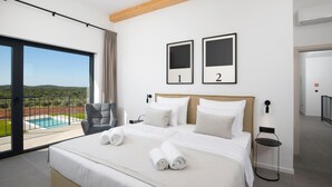 A modern hotel room with a large bed, a view of a pool, and two framed pictures on the wall. - Cozy home in Bale with sauna (Bale)
