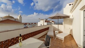 A rooftop terrace with a table, chairs, and a large umbrella. - Second Life Baleal - 350 meters to the sea (Peniche)