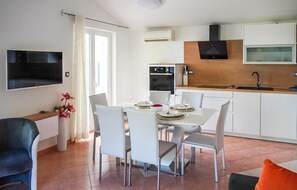 A modern kitchen with white cabinets, a black stove, and a wooden countertop. - 1 bedroom gorgeous apartment in Brsec (Brsec)