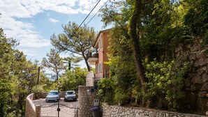 A stone-walled property with a gated driveway, parked cars, and lush greenery. - Lovely apartment in Brsec with WiFi (Brsec)