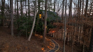 A forested area with a pathway leading to a small structure with a green roof. - Romantic Couples A-Frame · Hot Tub ·Outdoor Shower (Dahlonega)