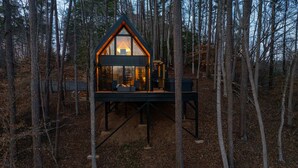 A cabin with a triangular roof, large windows, and a deck area. - Romantic Couples A-Frame · Hot Tub ·Outdoor Shower (Dahlonega)