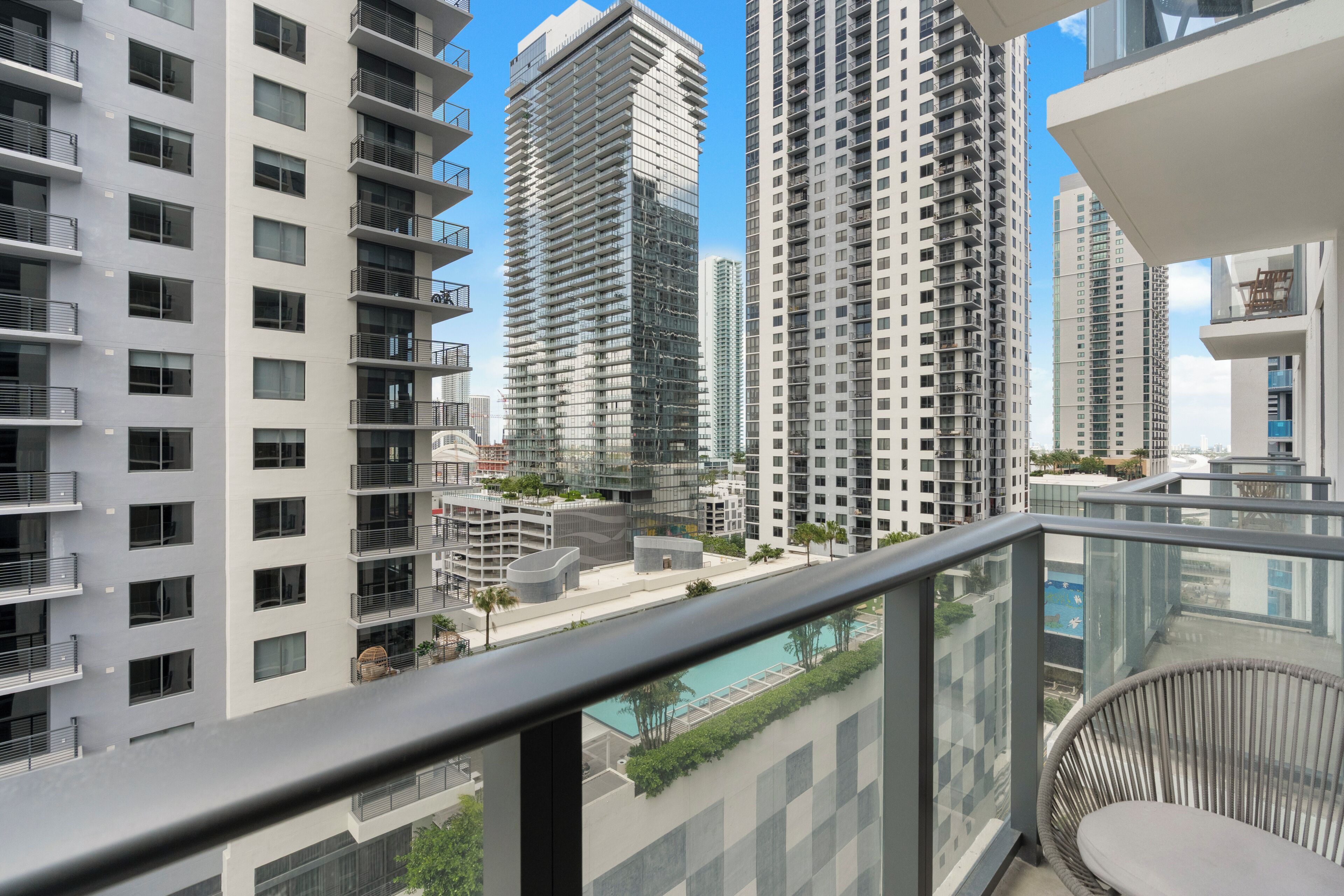Een hoog appartementencomplex met meerdere balkons, een zwembad en een modern architectuur.