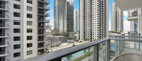 Een hoog appartementencomplex met meerdere balkons, een zwembad en een modern architectuur.