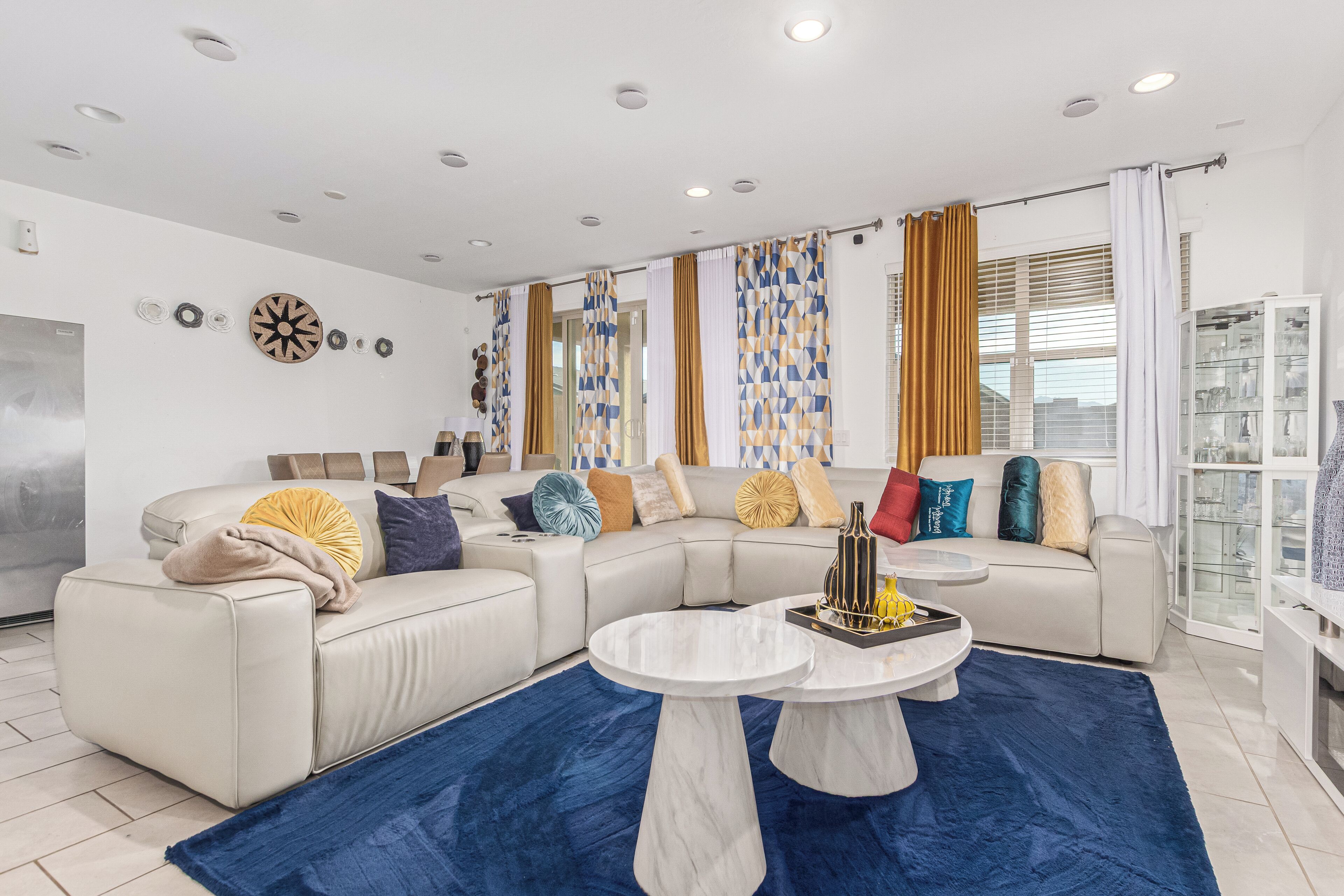 A modern living room with a sectional sofa, a coffee table, and a glass cabinet.