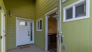 A green exterior with a white door labeled 'A', a welcome mat, and a small window. - Marbella Lane - Adorable and Quiet Studio (San Mateo)