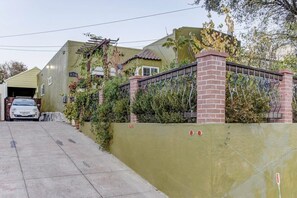 A residential property with a garage, a brick wall, and a metal gate. - Marbella Lane Cozy 2BR Studio Duplex Home (San Mateo)