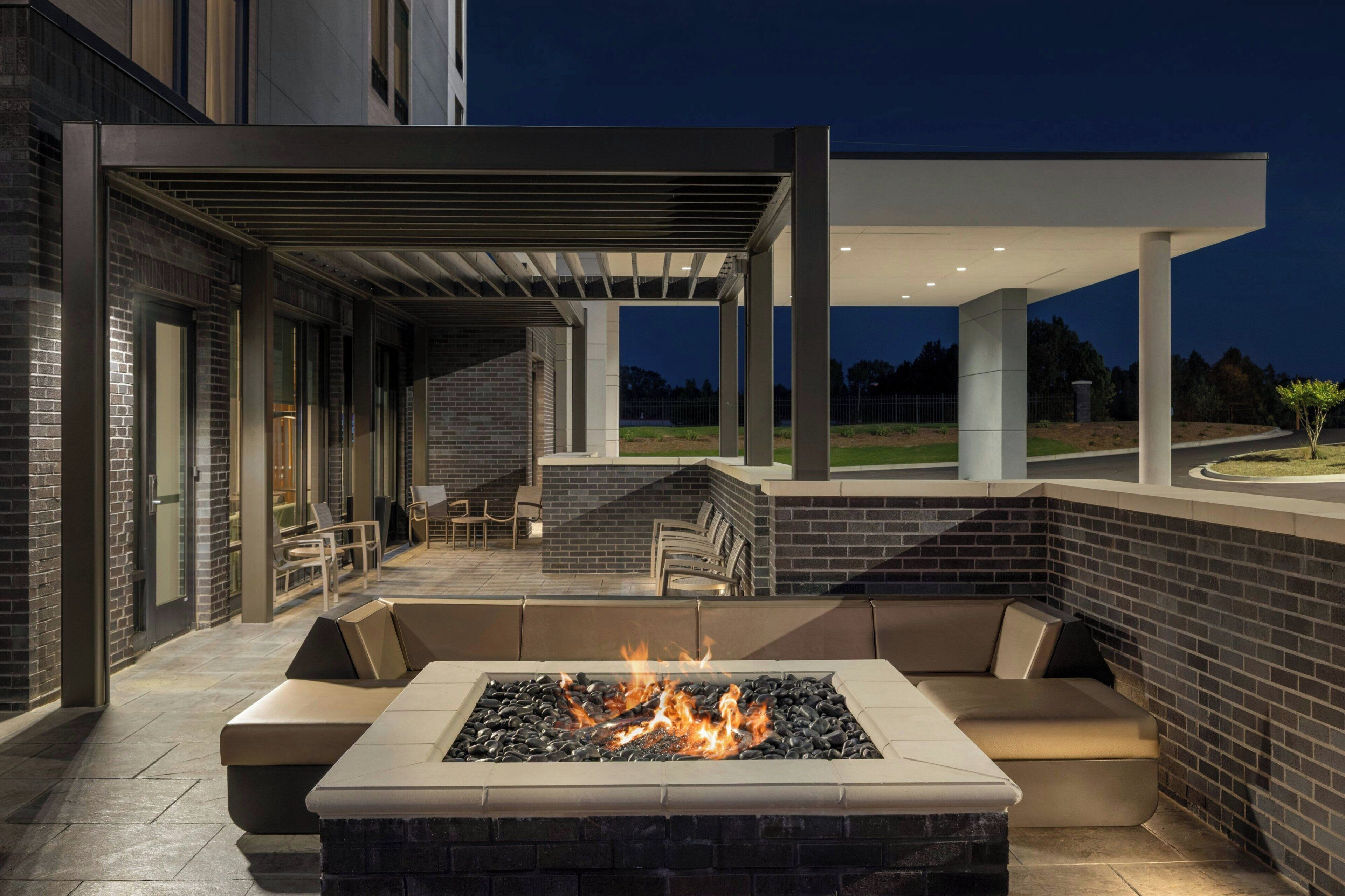 An outdoor seating area with a fire feature and a covered patio.
