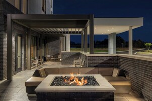 Un área de estar al aire libre con una chimenea y un porche cubierto.