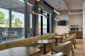 A modern bar area with seating, large windows, and a flat-screen TV. - Springhill Suites By Marriott Braselton (Hoschton)