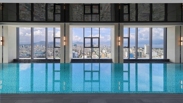 Una piscina interior moderna con amplios ventanales que ofrecen vistas de la ciudad.
