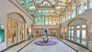 A spacious lobby with a central round table, large arched doors, and a stained glass ceiling. - Renaissance Goa Hotel (Arpora)