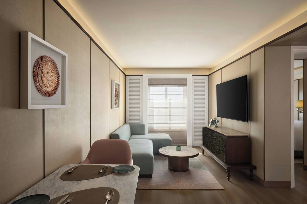 Ein modernes Wohnzimmer mit einer Couch, einem Couchtisch und einem an der Wand befestigten Flachbildfernseher.