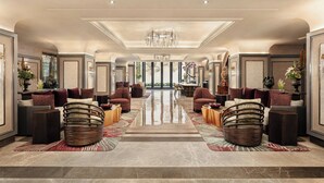 A spacious lobby with a central chandelier, seating areas with cushioned chairs, and a polished marble floor. - Renaissance Goa Hotel (Arpora)