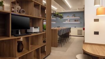 A modern kitchen with wooden cabinetry, a built-in stove, and a dining area with chairs and a table.