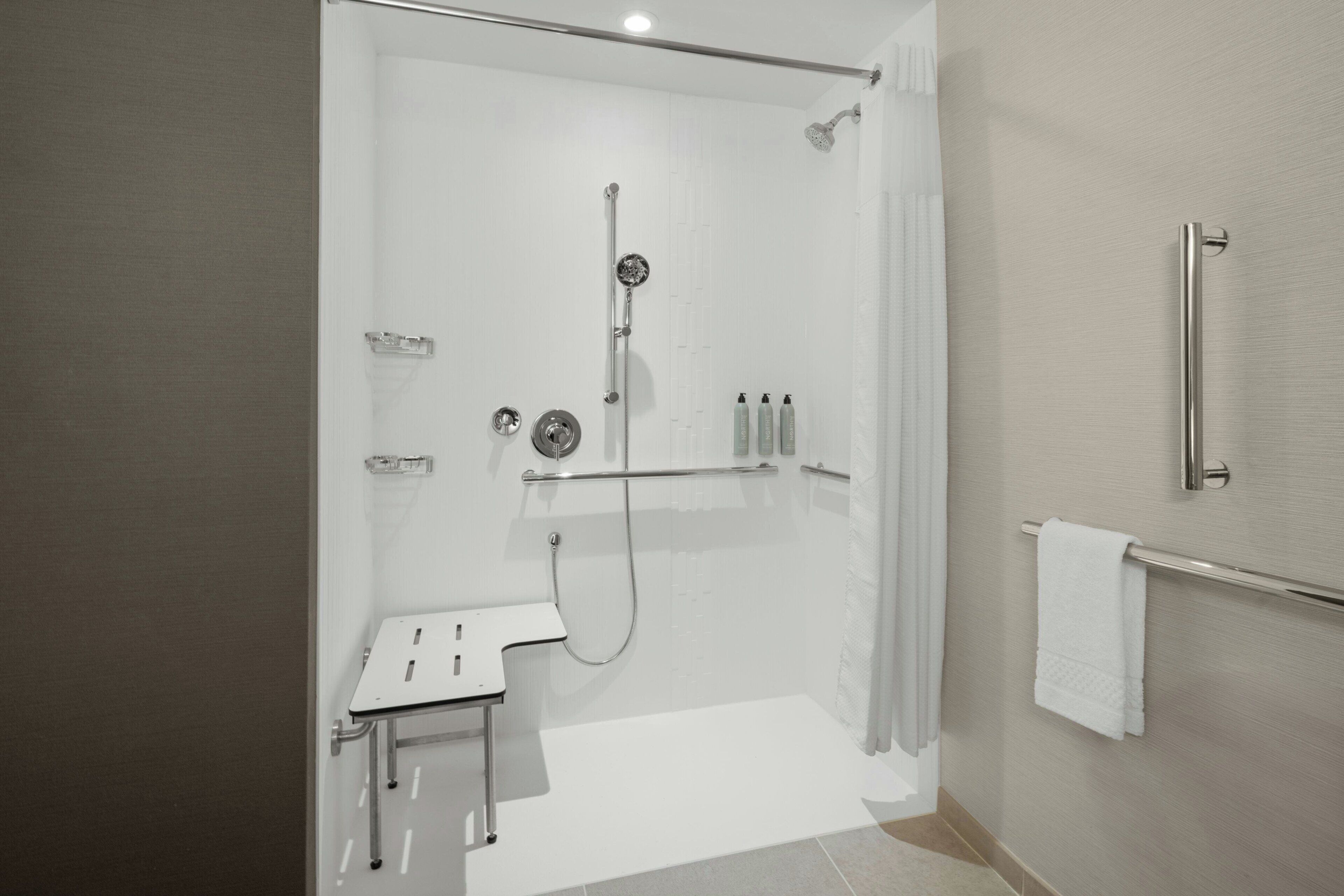 Ein modernes Badezimmer mit Dusche, Toilette und Handtuchhalter.