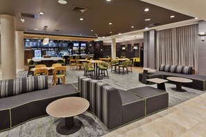 A modern lounge area with seating arrangements, a bar, and a television screen. - Courtyard By Marriott Sugar Mountain Banner Elk (Sugar Mountain)