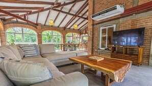 A spacious living area with a large sectional sofa, a wooden coffee table, and a flat-screen TV. - Rancho San Jose - Barra De Santiago (Barra de Santiago)