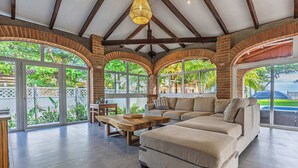 A spacious living room with a large sectional sofa, a wooden coffee table, and a hanging light fixture. - Rancho San Jose - Barra De Santiago (Barra de Santiago)