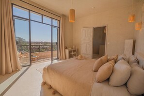 A spacious bedroom with a large bed, a desk, and a view of the outdoors. - Lalla Essaouira, Villa Khmissa, piscine chauffée et personnel (Essaouira)