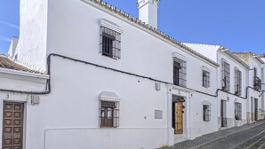 A white building with multiple windows, a wooden door, and a tiled roof. - Awesome home in Castilblanco de los Ar (Castilblanco de los Ar)