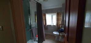 A bathroom with a toilet, a sink, and a shower area. - River View - 4 Bedroom Flat (Garve)