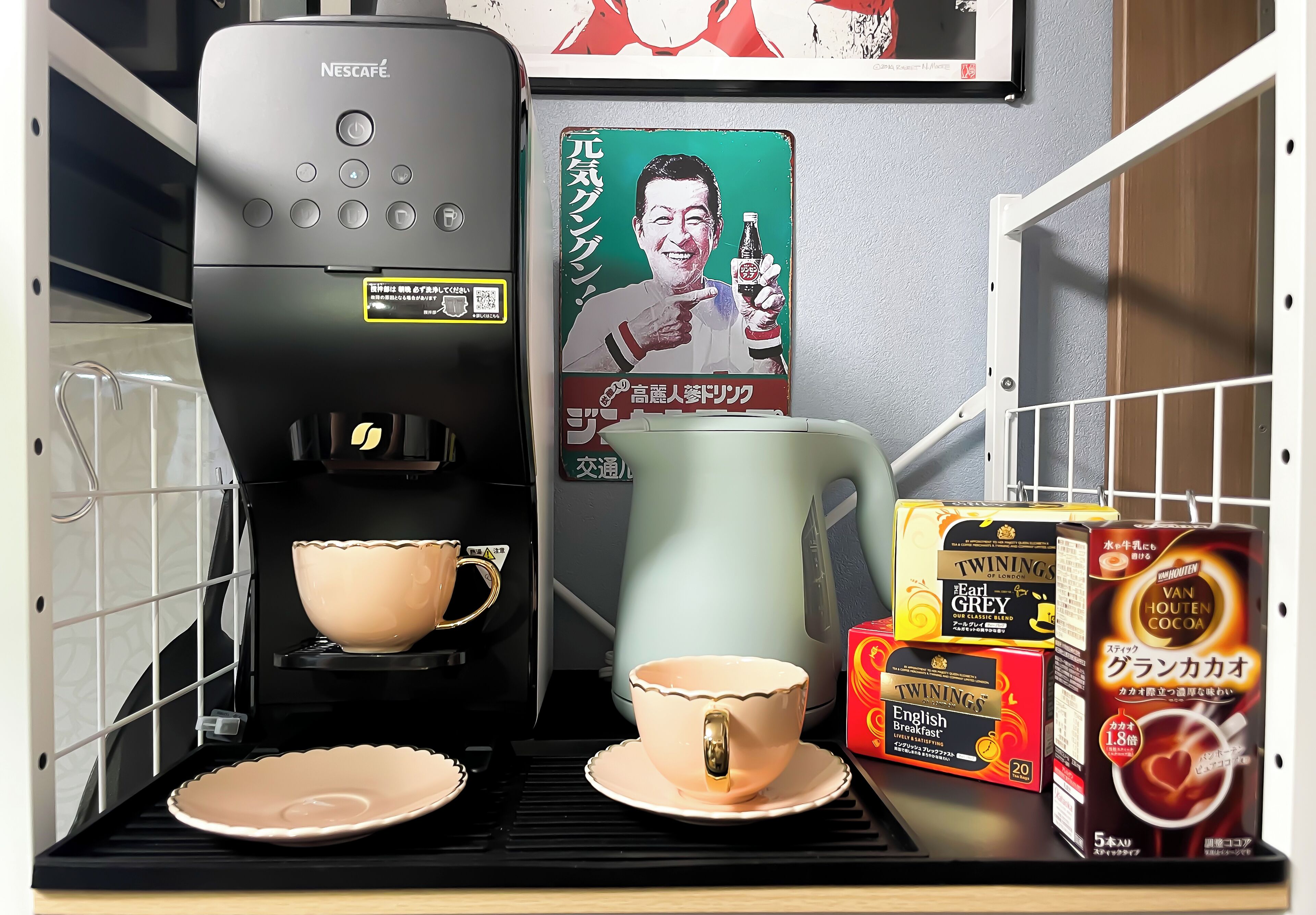 A coffee machine, two cups, and some coffee pods on a counter.