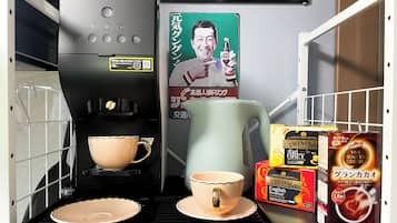 A coffee machine, two cups, and some coffee pods on a counter.